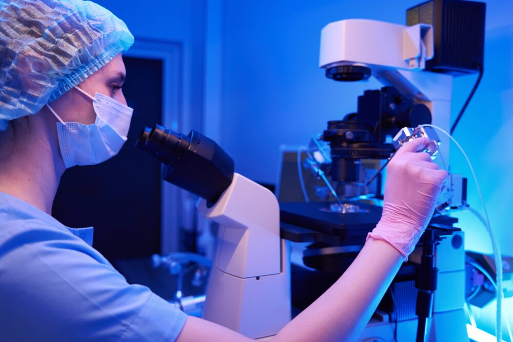 Scientist doing intracytoplasmic sperm injection, micromanipulation equipment